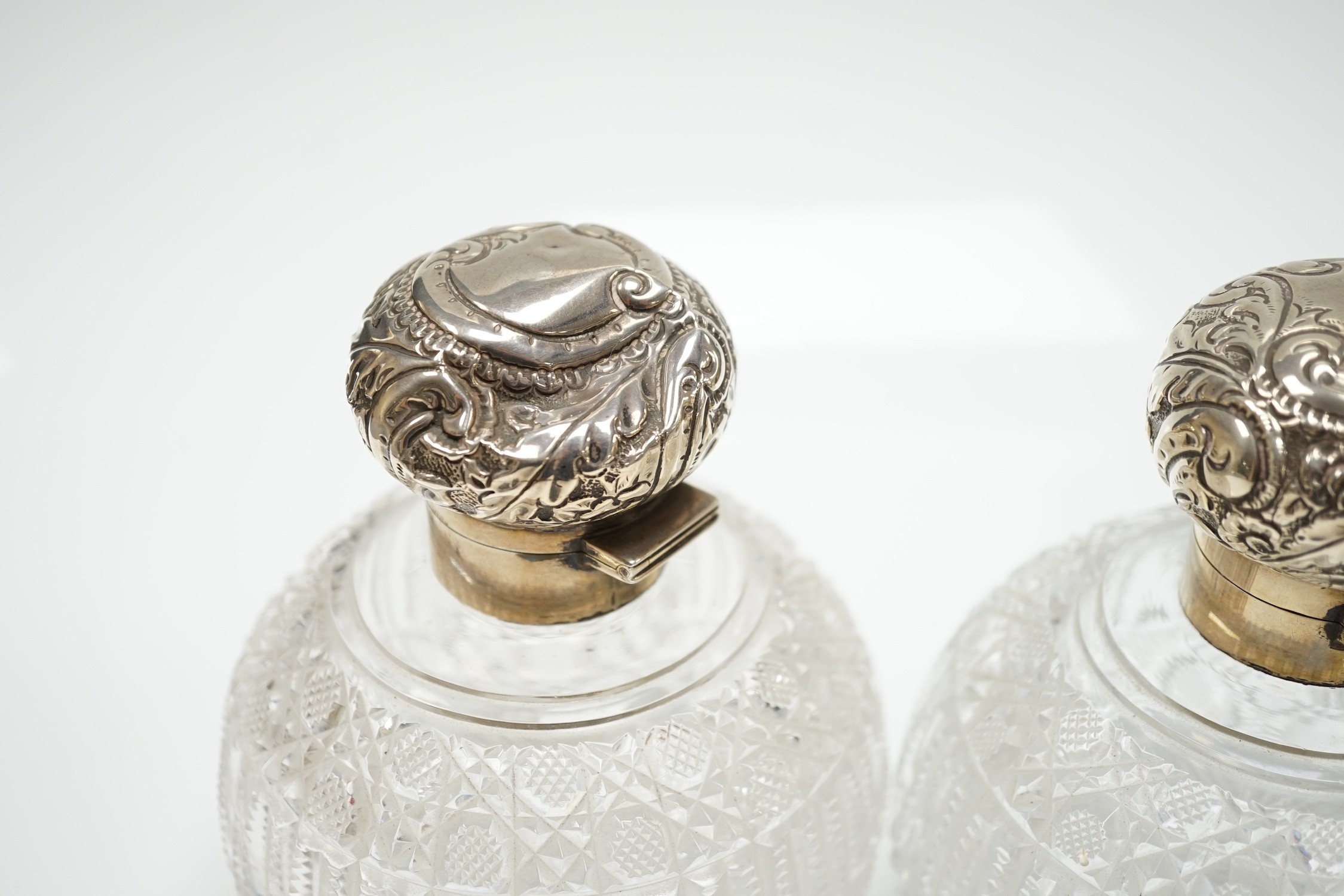 A pair of late Victorian silver mounted cut glass globular scent bottles (a.f.), Haseler Brothers, Birmingham, 1894/5, height 14.9cm.